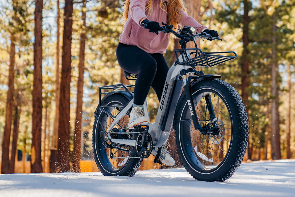 A woman riding the GOTRAX Tundra Fat Tire Off Road Electric Bike for Adults