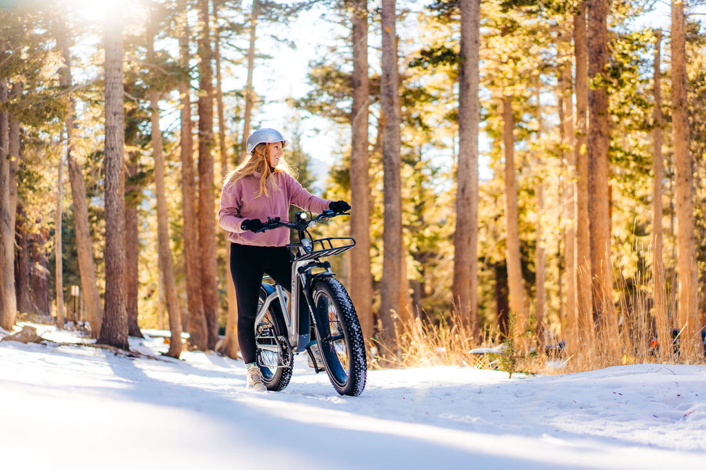 A woman standing in the snow with the GOTRAX Tundra Fat Tire eBike